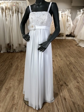 Weißes Schwangerschaftskleid mit Trägern und großer Blume am Gürtel an einer schwarzen Schaufensterpuppe im Brautladen
