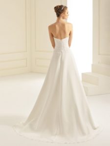 Brünettes Model mit A-Linienbrautkleid mit Spitzencorsage indoor von hinten